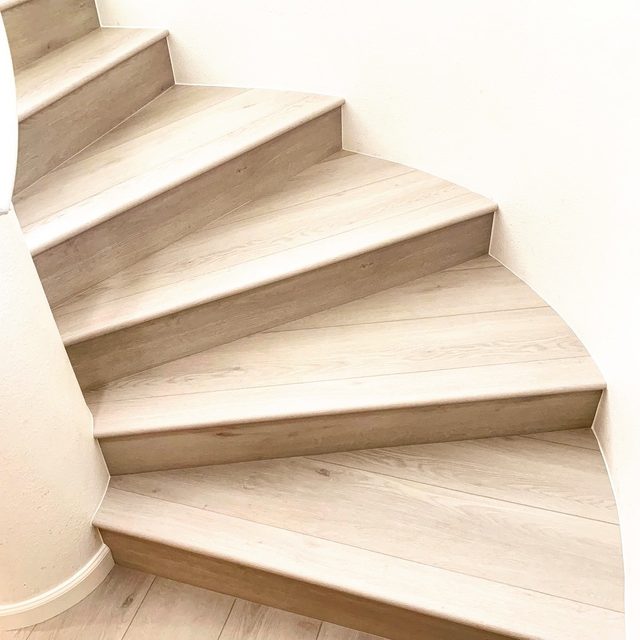 After: curved stairs with new vinyl plank treads and white risers