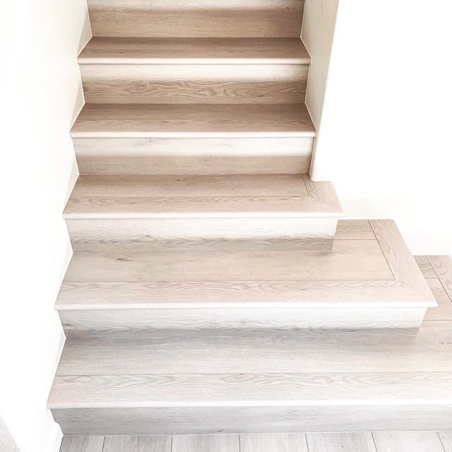 After: staircase with vinyl plank treads and white risers