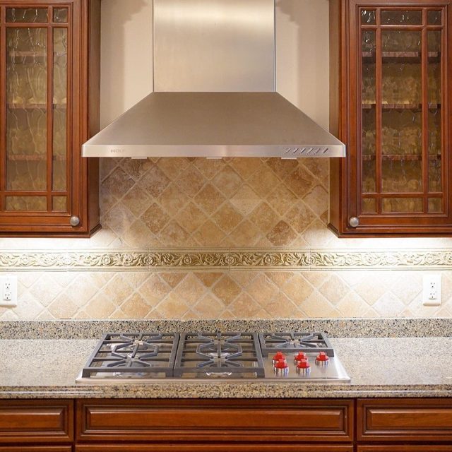 Before: dated travertine tile backsplash behind the range