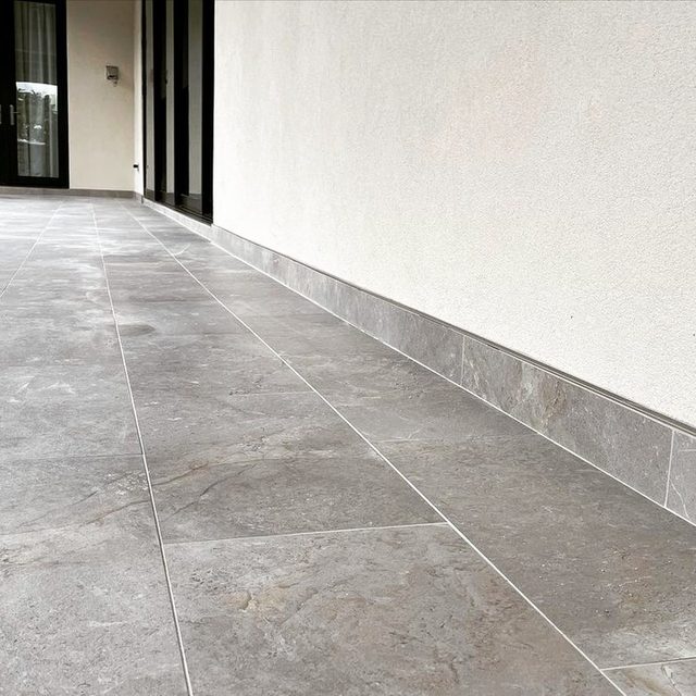 Large-format porcelain patio tile with matching tile baseboard